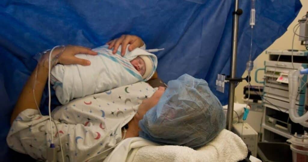 New mom holding baby in OR after gentle cesarean birth