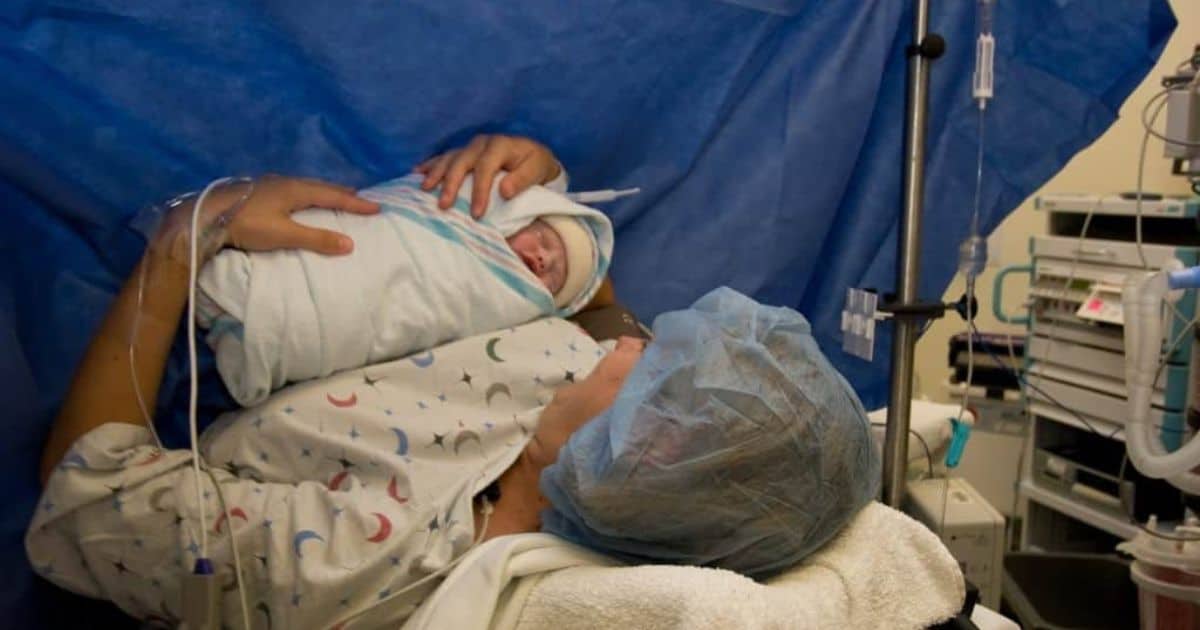New mom holding baby in OR after gentle cesarean birth