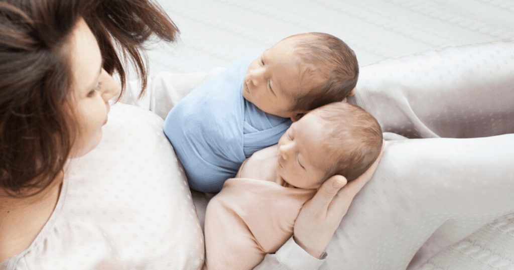 newborn twin babies with mother nursery setup