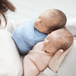 newborn twin babies with mother nursery setup