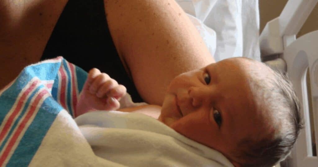 newborn baby wrapped in hospital blanket