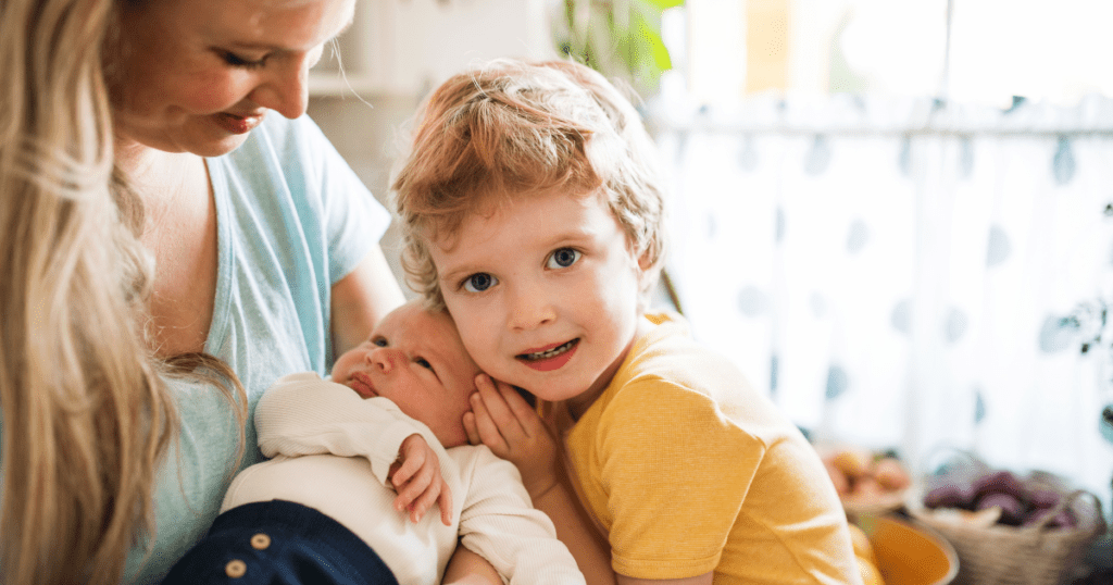 Toddler Hugging his Newborn Baby Sister