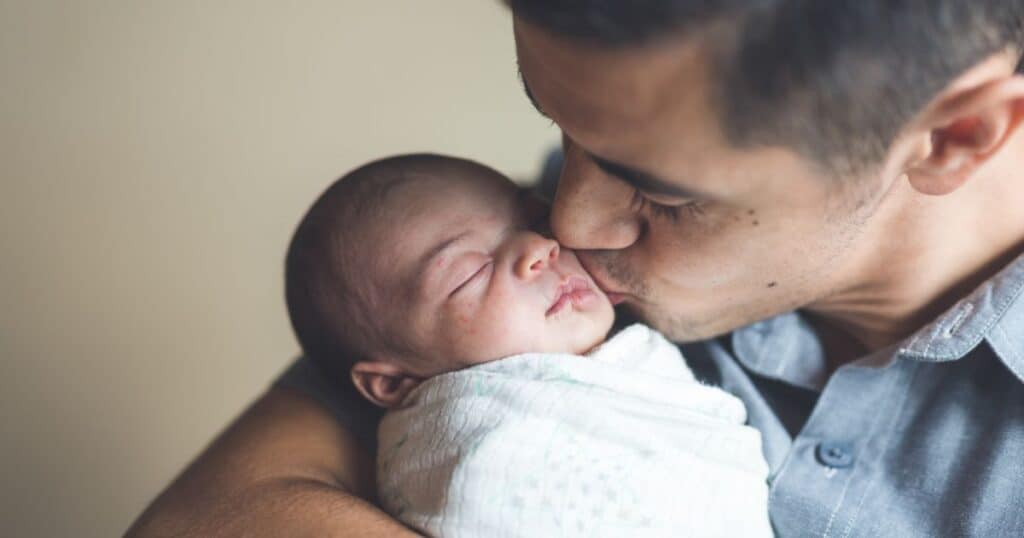 new dad kissing baby