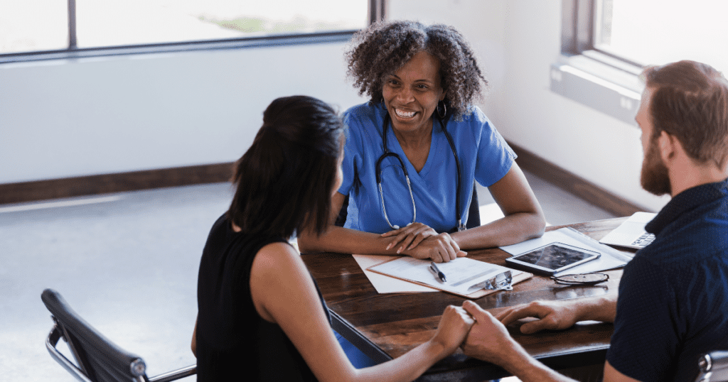 Choosing an OB/GYN or Midwife, a care provider sits with a family