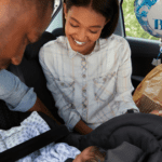 Bringing Baby Home, new parents in the car putting baby in car seat
