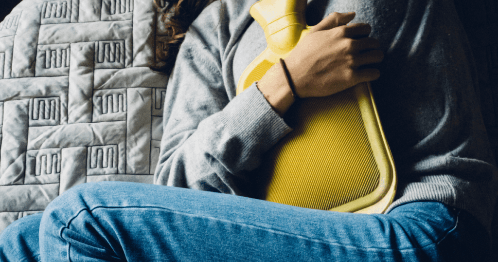 Holding a Hot Water Bottle on her abdomen, Childbirth Afterpains