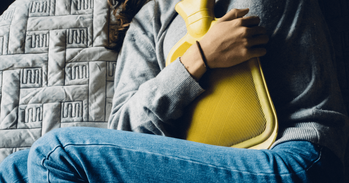 Holding a Hot Water Bottle on her abdomen, Childbirth Afterpains