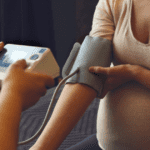 taking blood pressure of a pregnant mother, monitoring for preeclampsia