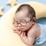 Newborn sleeping on a moon pillow with star pillows around him