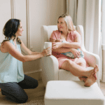 A doula offering a cup of tea to a new mom, why choose a doula agency?