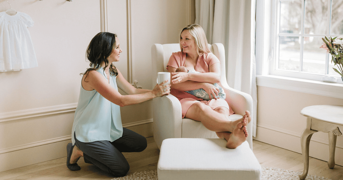 A doula offering a cup of tea to a new mom, why choose a doula agency?
