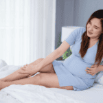 Pregnant women holding leg in pain, pregnancy ailments