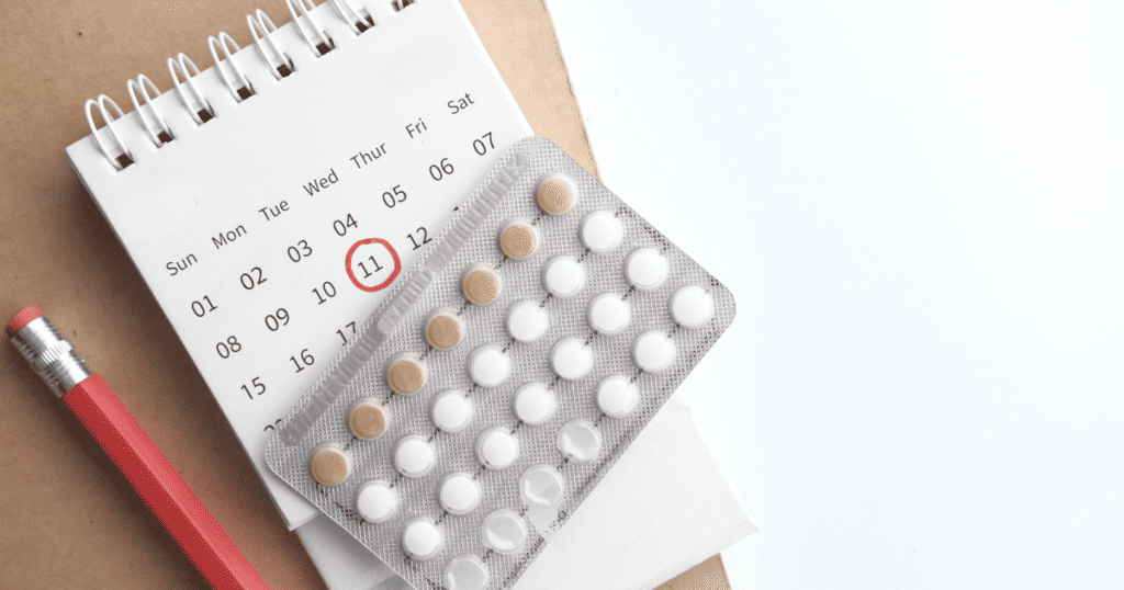 Postpartum Birth Control Guide, pills on top of a calendar with a pencil