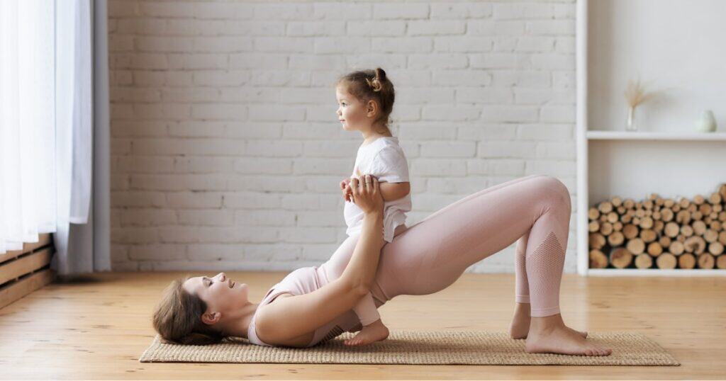 Mom with her daughter on her lap, doing a glute bridge, diastases recti