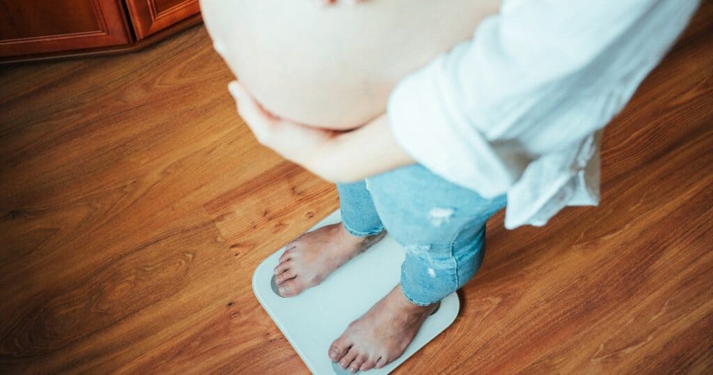 pregnant mom standing on a scale, pregnancy weight gain
