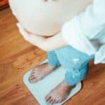 pregnant mom standing on a scale, pregnancy weight gain
