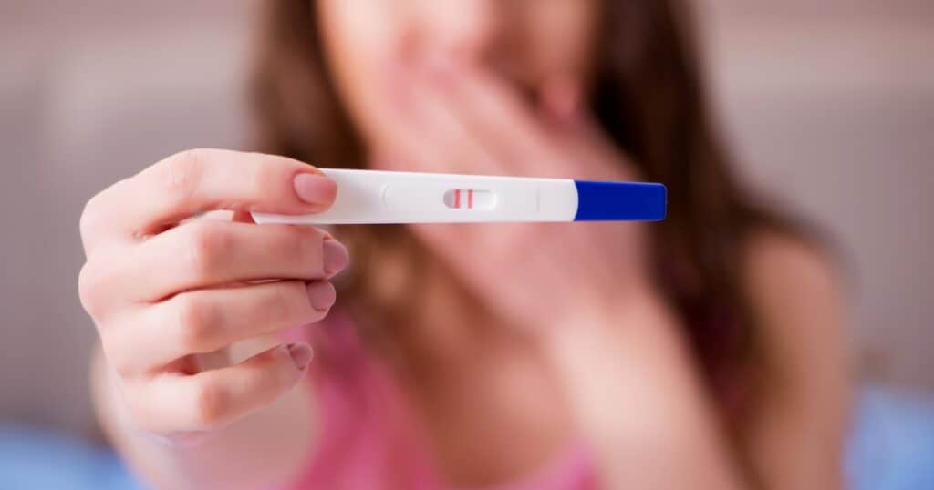 early pregnancy signs, lady holding up a pregnancy test