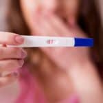 early pregnancy signs, lady holding up a pregnancy test