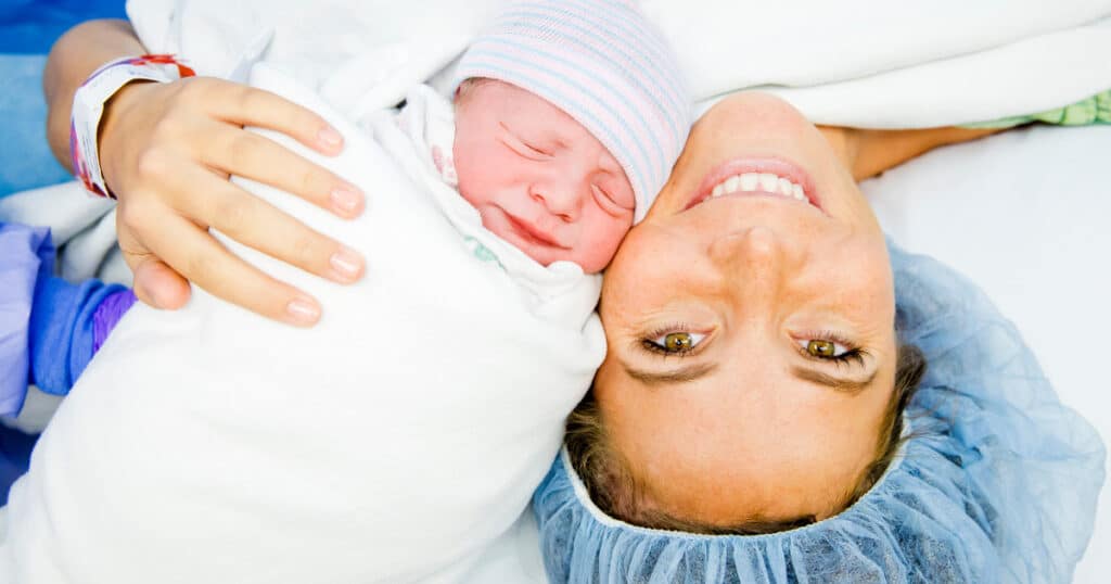 Mom having a C-Section holding her baby in the operating room, Do I need a Doula for a C-Section