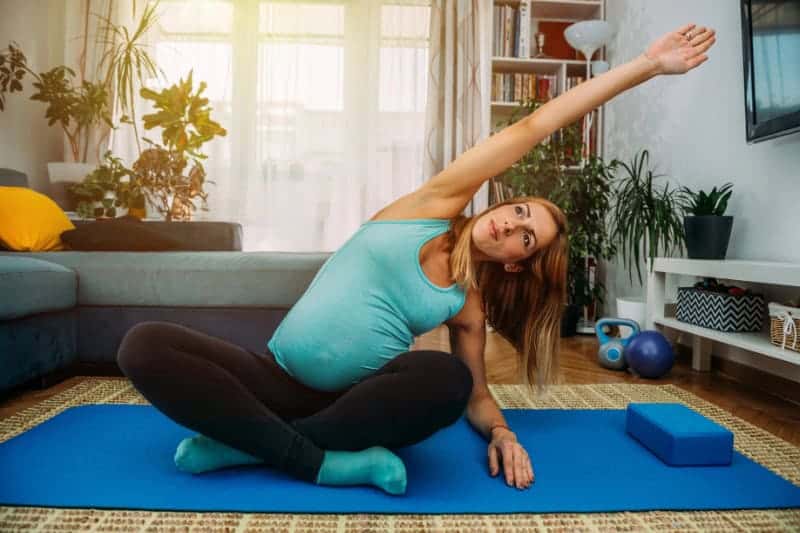 pregnant woman in yoga class stretching
