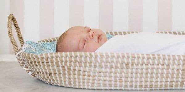 newborn baby swaddled in basket