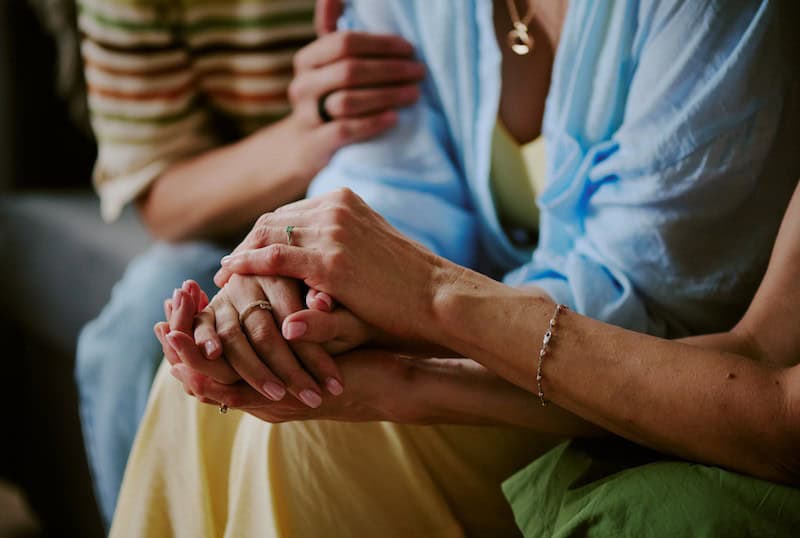 comforting hands supporting each other at a support group