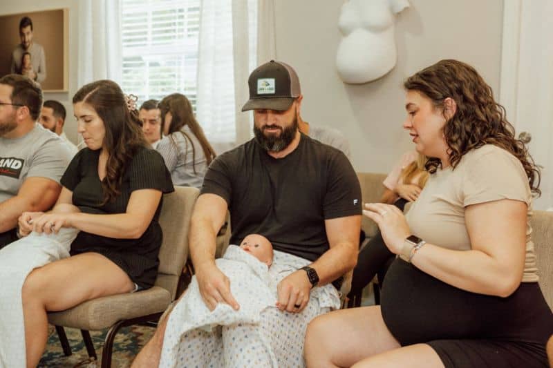 pregnant couple practice swaddling at Tampa newborn care class with Buddha Belly Doulas