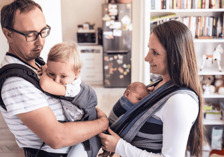 Two parents wearing their babies, babywearing guide