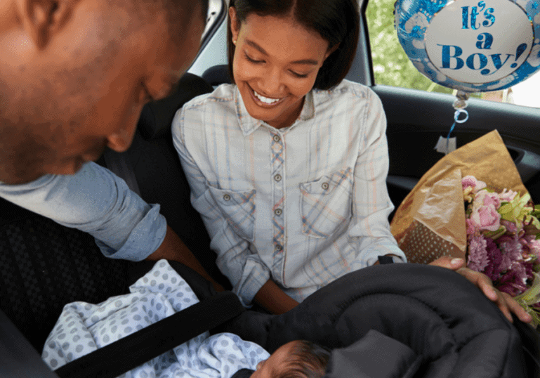 Bringing Baby Home, new parents in the car putting baby in car seat