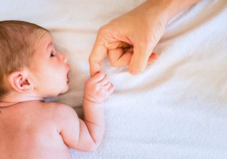 the first six weeks postpartum, newborn baby holds parents finger