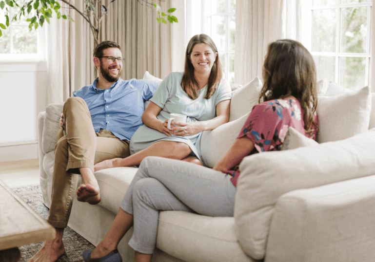 Birth Doulas Meeting with a Pregnant Couple sitting on a couch