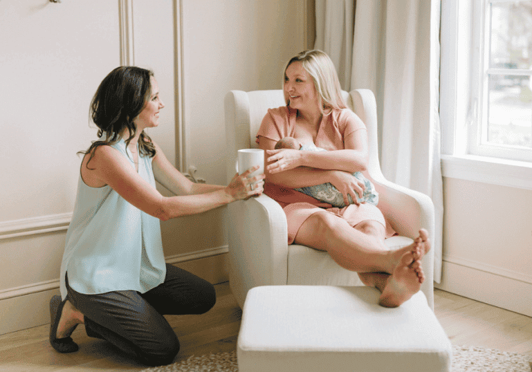 A doula offering a cup of tea to a new mom, why choose a doula agency?