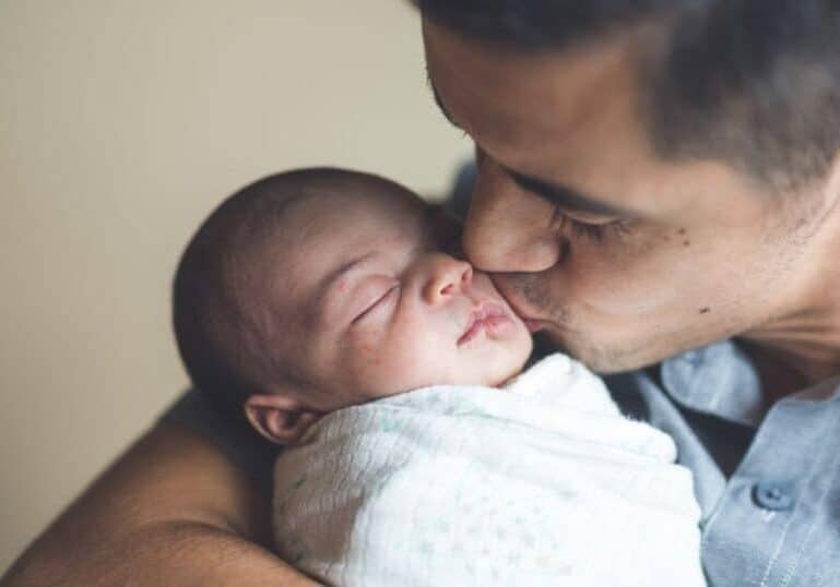 new dad kissing baby