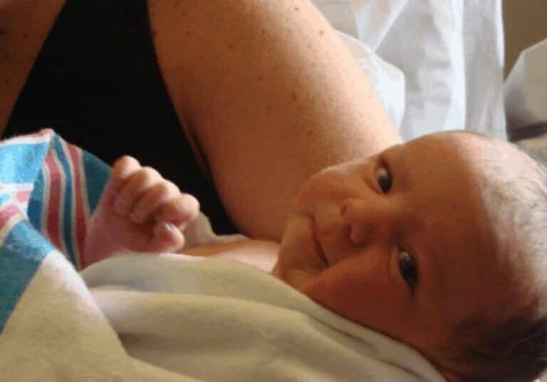newborn baby wrapped in hospital blanket